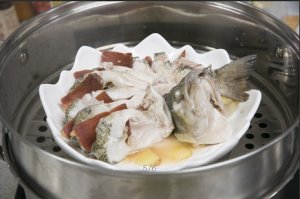 將鱸魚成花狀擺好，將火腿切片放入各縫隙中，放入鍋中隔水蒸12分鐘拿出，撒上蔥花即可。