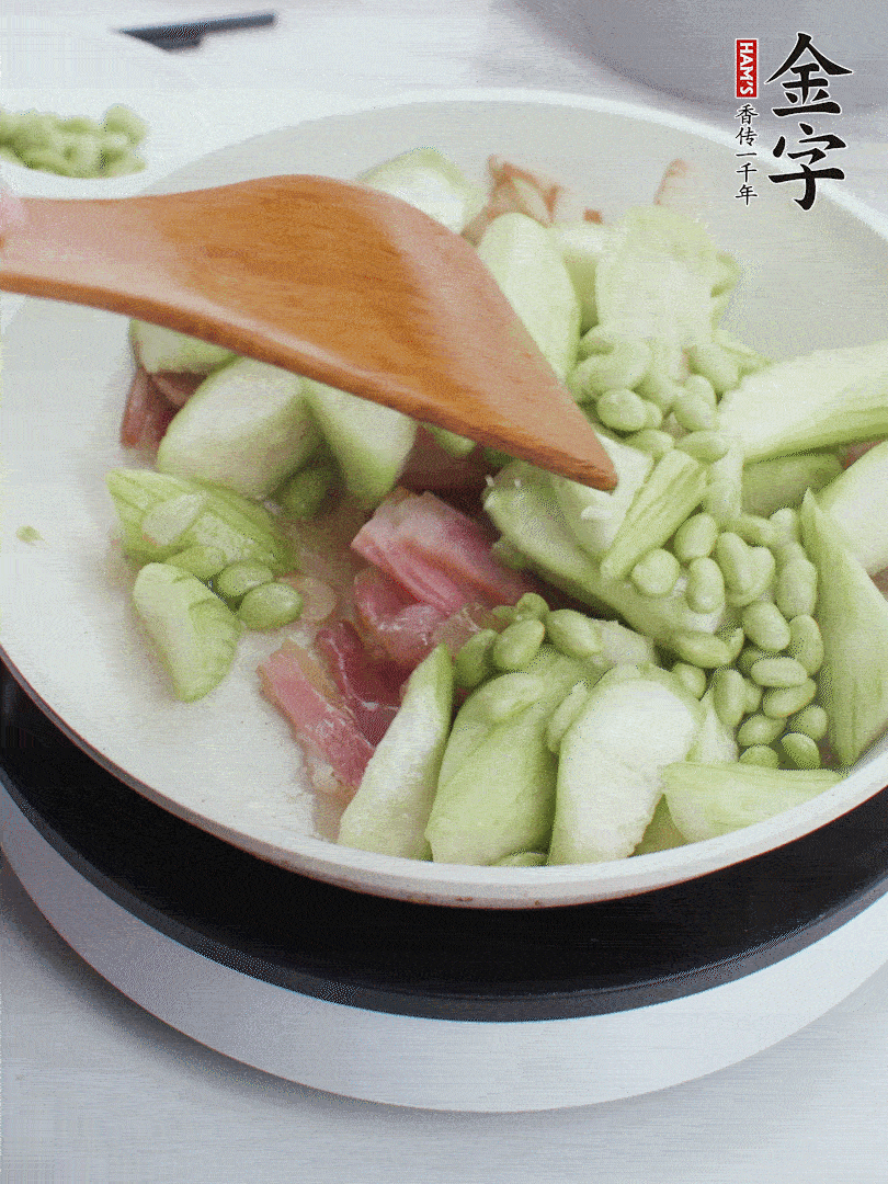 依次下絲瓜、青豆翻炒，炒至絲瓜打蔫縮小。