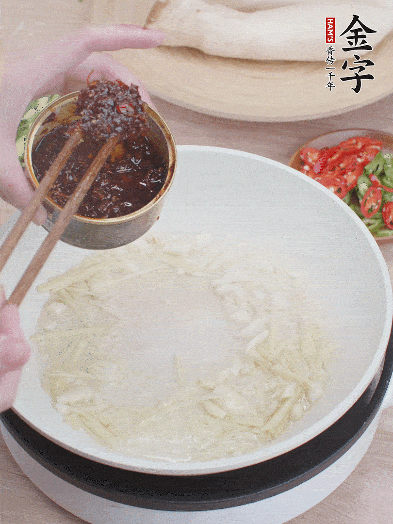 起鍋熱油，姜蒜、金字火腿干貝醬煸香。