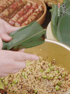 粽葉往下折，完全蓋住，兩側(cè)捏緊。