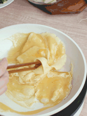油6成熱時，下雞蛋液，邊緣凝固時翻拌成塊狀。