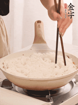 把瀝干水分的米飯均勻鋪在上面，筷子戳幾個洞，以便透氣，轉(zhuǎn)小火蓋上蓋子燜至水分收干，大概10分鐘。